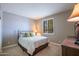 Bedroom featuring queen bed, a window, and dresser at 16913 W Holly St, Goodyear, AZ 85395