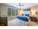Bright bedroom featuring a king bed with plush blue bedding and large windows at 16913 W Holly St, Goodyear, AZ 85395
