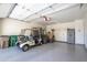 Spacious garage features epoxy floors, storage cabinets, and a golf cart with seating, providing ample space at 16913 W Holly St, Goodyear, AZ 85395