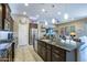 Open kitchen with a central island, pendant lighting, stainless steel appliances, and a view into the living area at 16913 W Holly St, Goodyear, AZ 85395