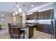 Modern kitchen featuring dark wood cabinets, granite countertops, stainless steel appliances, and a breakfast bar at 16913 W Holly St, Goodyear, AZ 85395