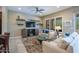 Bright living room with a ceiling fan, tile floors, comfortable seating, and access to the outdoors at 16913 W Holly St, Goodyear, AZ 85395