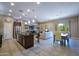 Open-concept kitchen and living space with island seating and stainless appliances at 16913 W Holly St, Goodyear, AZ 85395