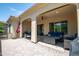 Paver patio with covered seating, grill, and palm trees overhead at 16913 W Holly St, Goodyear, AZ 85395