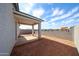 Large backyard with a covered patio, block wall and low-maintenance landscaping, ready for your personal touch at 17290 W Daley Ln, Surprise, AZ 85387