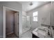 Bright bathroom featuring a double sink vanity with granite countertop and a glass-enclosed shower at 17290 W Daley Ln, Surprise, AZ 85387