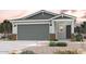 Charming exterior elevation featuring a two-car garage, desert landscaping, and inviting front porch at 17290 W Daley Ln, Surprise, AZ 85387