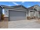 Charming exterior elevation featuring a two-car garage, desert landscaping, and inviting front porch at 17290 W Daley Ln, Surprise, AZ 85387