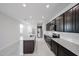 Stylish kitchen with dark cabinetry, granite countertops, and stainless steel appliances at 17290 W Daley Ln, Surprise, AZ 85387