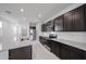 Modern kitchen featuring dark wood cabinets, granite countertops, and stainless steel appliances at 17290 W Daley Ln, Surprise, AZ 85387