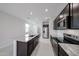 Modern kitchen featuring stainless steel appliances, granite countertops, tile backsplash, and ample cabinet space at 17290 W Daley Ln, Surprise, AZ 85387