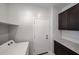 Laundry room with dark cabinets, light countertop, and a white door at 17290 W Daley Ln, Surprise, AZ 85387