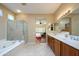 Bathroom with shower, tub, double vanity, and access to main bedroom at 21003 N Circle Cliffs Dr, Surprise, AZ 85387