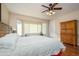 Spacious main bedroom with wood floors, ceiling fan, bay window, and a door to the outside at 21003 N Circle Cliffs Dr, Surprise, AZ 85387