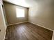 Cozy bedroom featuring wood floors, a bright window, and neutral walls at 2133 W Turney Ave # C88, Phoenix, AZ 85015