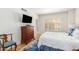 Bright bedroom with a wood dresser, TV, window with shutters, and hardwood floors at 2201 N Central Ave # 3D, Phoenix, AZ 85004