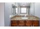 Bathroom with granite countertop and vanity, framed mirror and lighting fixture at 231 N Nash Way, Chandler, AZ 85225