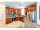 Gourmet kitchen featuring granite countertops, a tile backsplash, stainless steel appliances, and dark wood cabinets at 231 N Nash Way, Chandler, AZ 85225