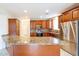 Well-equipped kitchen featuring a large island, wooden cabinets, granite countertops, and stainless steel appliances at 231 N Nash Way, Chandler, AZ 85225