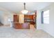 Open-concept kitchen featuring wooden cabinets, granite countertops, stainless steel appliances, and tile flooring at 231 N Nash Way, Chandler, AZ 85225