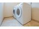 A laundry room featuring a stacked washer and dryer set with tile floors at 231 N Nash Way, Chandler, AZ 85225