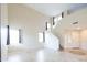 Bright living room featuring tile floors, soaring ceilings and light-colored walls with a staircase at 231 N Nash Way, Chandler, AZ 85225