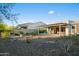 Spacious backyard with covered patio, complemented by desert landscaping and native vegetation at 3020 N 165Th Ave, Goodyear, AZ 85395