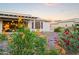 Beautiful backyard with vibrant flowers and a covered patio, creating a serene outdoor living space at 3020 N 165Th Ave, Goodyear, AZ 85395
