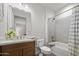 Bright bathroom with a wooden vanity, shower and tub combo at 3020 N 165Th Ave, Goodyear, AZ 85395