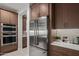 A modern kitchen featuring stainless steel appliances, double ovens and custom wood cabinetry at 3020 N 165Th Ave, Goodyear, AZ 85395