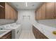 Bright laundry room with upper and lower cabinets and modern appliances at 3020 N 165Th Ave, Goodyear, AZ 85395