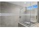 Modern shower with gray tile, glass enclosure, and a view to the outdoors at 3020 N 165Th Ave, Goodyear, AZ 85395