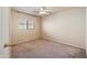 Cozy bedroom featuring carpet floors, a ceiling fan, and a window at 3027 W Red Fox Rd, Phoenix, AZ 85083