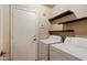 Functional laundry area with washer, dryer, and shelves at 3027 W Red Fox Rd, Phoenix, AZ 85083