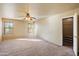 Spacious main bedroom with carpet, ceiling fan, closet, and bright windows at 3027 W Red Fox Rd, Phoenix, AZ 85083