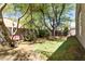 Lush backyard featuring a pink bench and a charming, private putting green surrounded by mature trees at 30434 N Palo Brea Dr, Scottsdale, AZ 85266