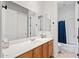 Bathroom with dual mirrors, and a shower-tub combo with a stylish blue curtain at 30434 N Palo Brea Dr, Scottsdale, AZ 85266