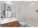A bright bathroom includes a single sink vanity, toilet, and shower-tub combination with a ceiling fan at 30434 N Palo Brea Dr, Scottsdale, AZ 85266