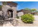 Beautiful home featuring an arched entry and wrought iron gate, plus desert landscaping at 30434 N Palo Brea Dr, Scottsdale, AZ 85266