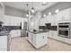 Spacious kitchen features white cabinets, stainless steel appliances, granite counters, and an island for culinary convenience at 30434 N Palo Brea Dr, Scottsdale, AZ 85266