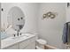 Elegant powder room with a modern oval mirror, designer faucet, and stylish wall decor at 30434 N Palo Brea Dr, Scottsdale, AZ 85266