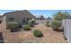 A gravel filled backyard featuring a covered patio, shrubbery, and perimeter fencing at 31006 W Weldon Ave, Buckeye, AZ 85396