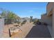 A gravel filled backyard featuring a small tree, shrubbery, a sandbox, and perimeter fencing at 31006 W Weldon Ave, Buckeye, AZ 85396