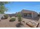 An expansive backyard with gravel landscaping, shrubbery, a sandbox, and perimeter fencing at 31006 W Weldon Ave, Buckeye, AZ 85396
