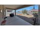 A covered patio with gravel landscaping, a grill, a small tree, and a sandbox at 31006 W Weldon Ave, Buckeye, AZ 85396