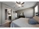 A bright bedroom with an adjacent bathroom, ceiling fan, dresser and comfortable carpet for convenience and comfort at 31006 W Weldon Ave, Buckeye, AZ 85396