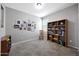 Spacious bedroom with carpet flooring, a bookshelf, chair, and a gallery wall, with a window allowing natural light at 31006 W Weldon Ave, Buckeye, AZ 85396