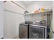 Modern laundry room featuring front-loading washer and dryer with a shelf above for storage of laundry supplies at 31006 W Weldon Ave, Buckeye, AZ 85396