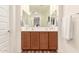 Bathroom vanity with double sinks, wood cabinets, large mirror, and modern fixtures at 36203 N Urika Dr, San Tan Valley, AZ 85140
