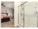 Bathroom with tiled shower, glass door, and adjacent bedroom with comfortable furnishings at 36203 N Urika Dr, San Tan Valley, AZ 85140